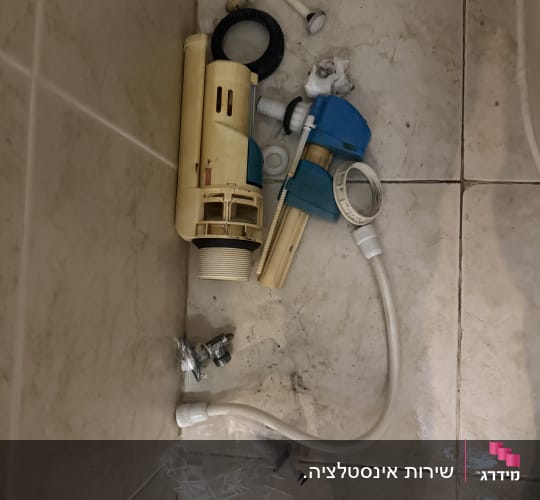 חלקי אינסטלציה על רצפת חדר אמבטיה